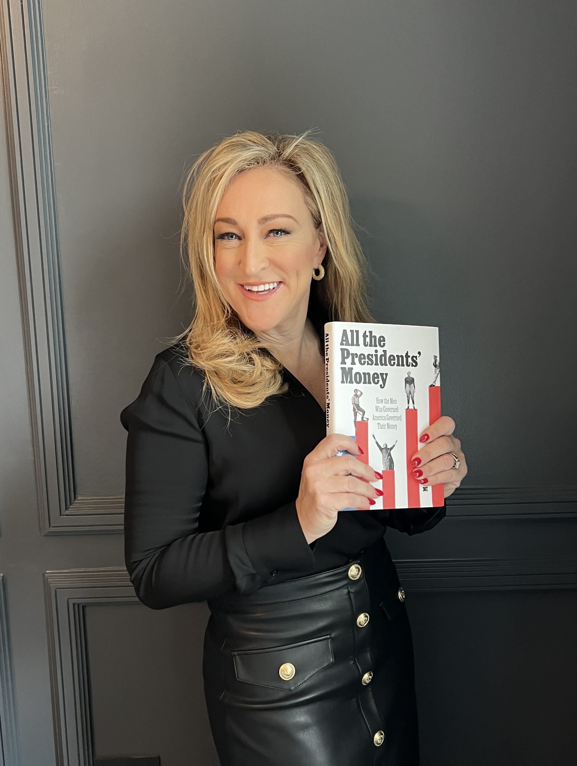 Author Megan Gorman holding a copy of her book All the Presidents' Money