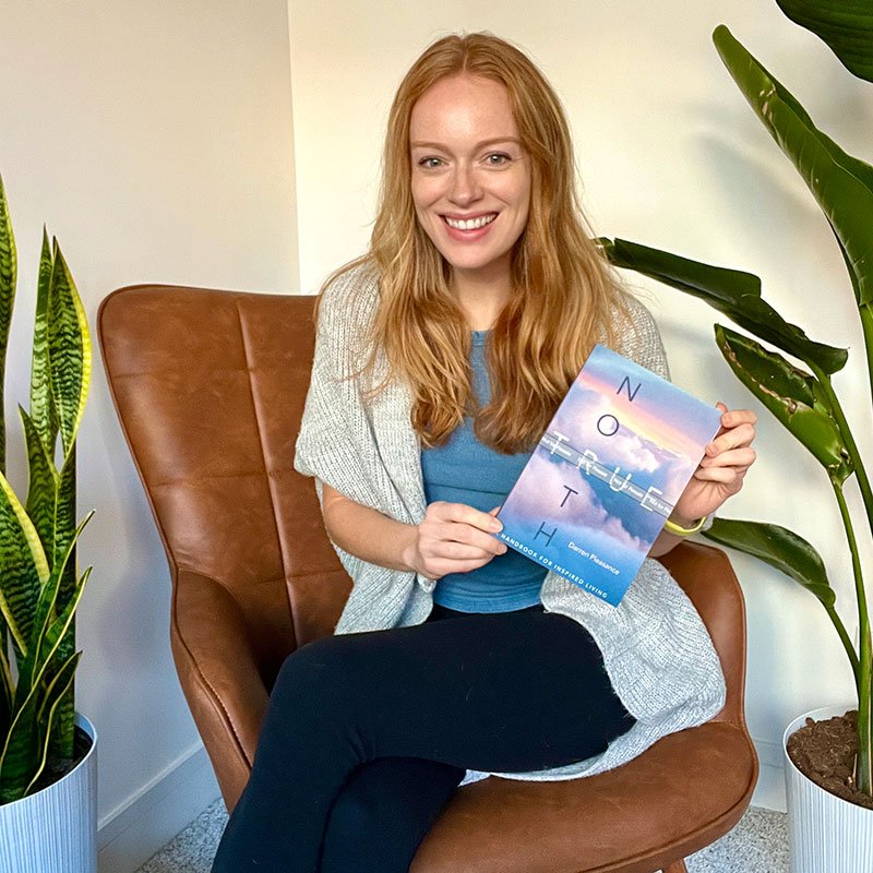 Amelia Forczak holding a copy of the book True North