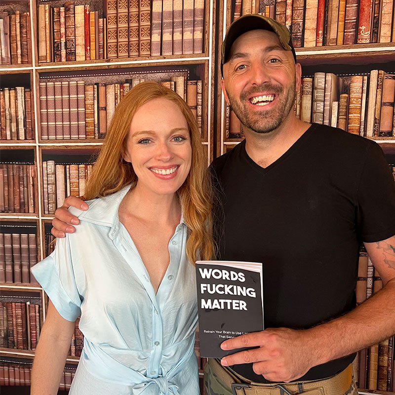 Andy Weins holding a copy of his book Words Fucking Matter