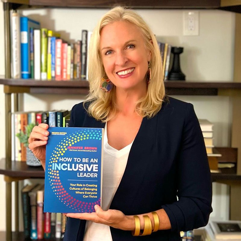 Author Jennifer Brown holding a copy of her book How to be an Inclusive Leader